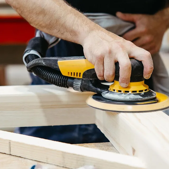 Mann som finpusser trekonstruksjon