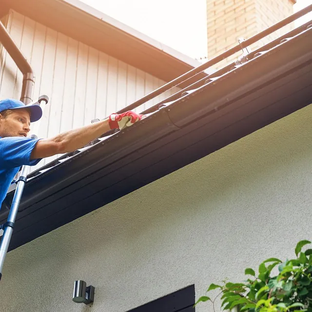 Man som rensker takrenne